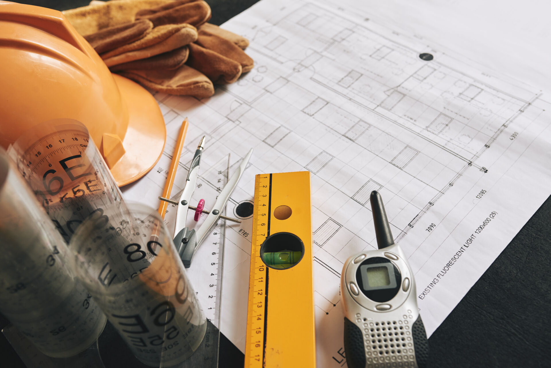Different belongings of engineer on blueprint of building